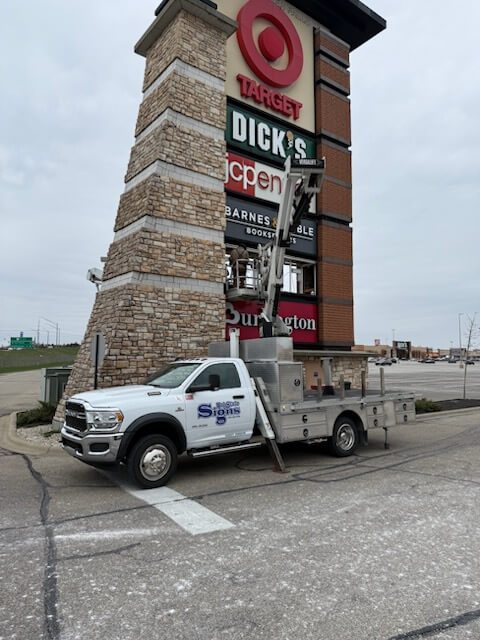 Tri-State Signs crew installing a Target pylon sign with a bucket truck